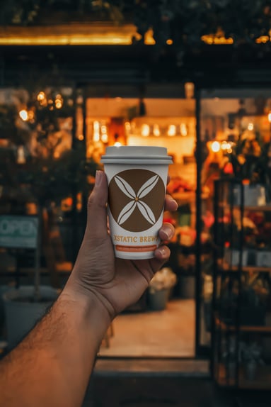 An image of a hand holding a Cup of Xstatic Brew.